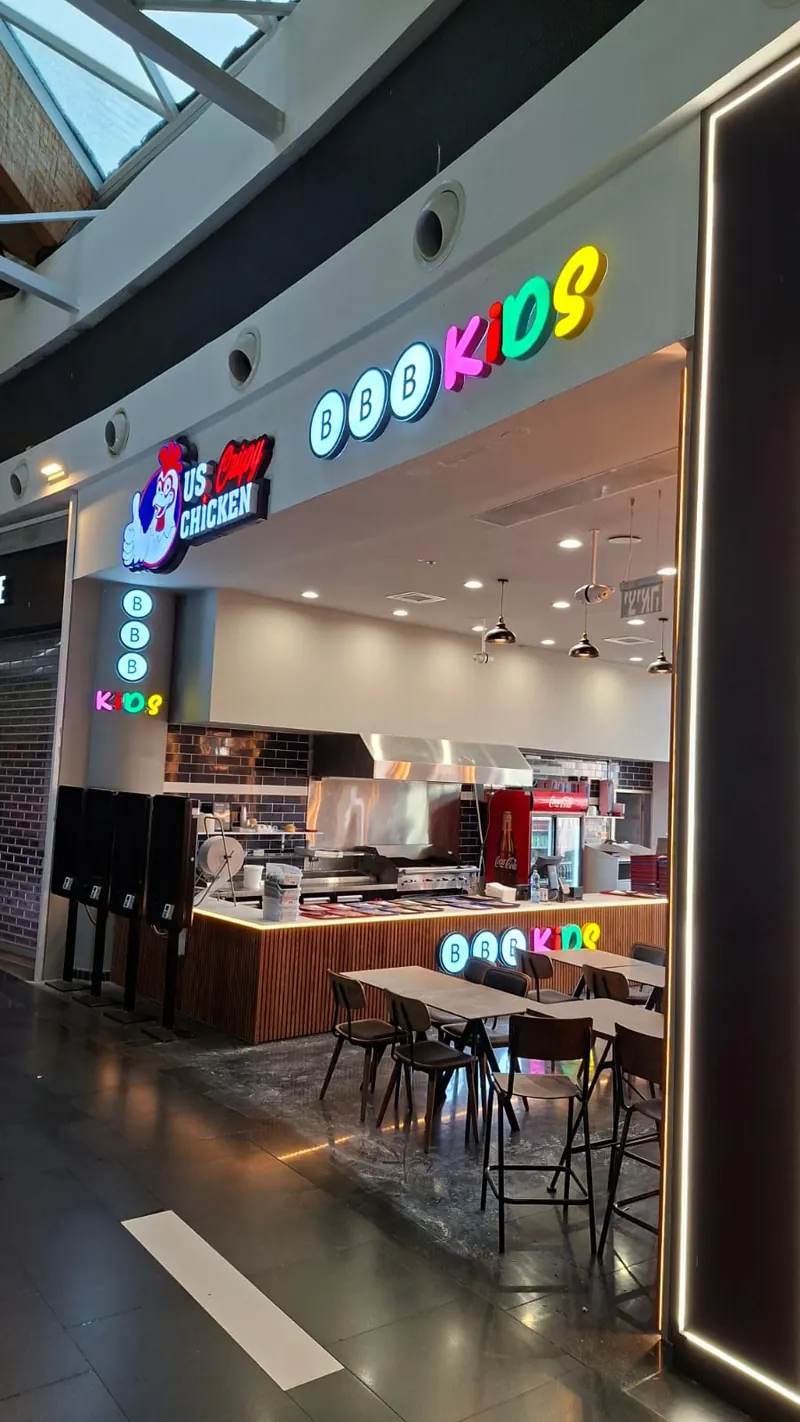 Front-lit channel letters on a retail store entrance — BBB Kids and US Crispy Chicken illuminated signs