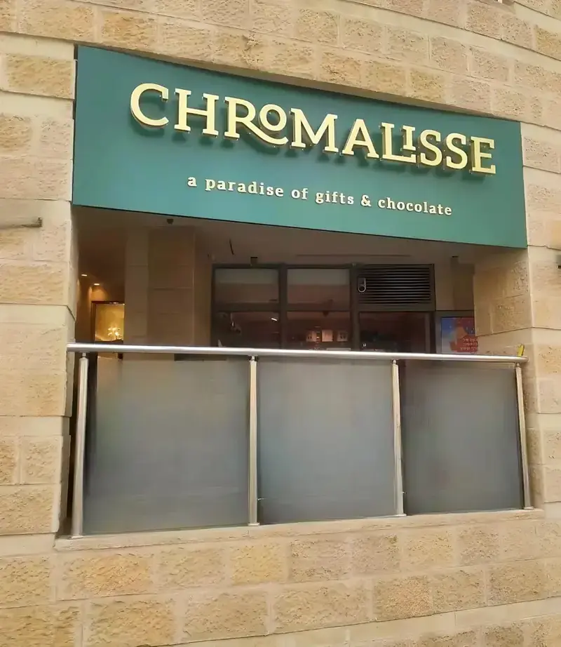 Gold halo-lit letters on an olive green sign face