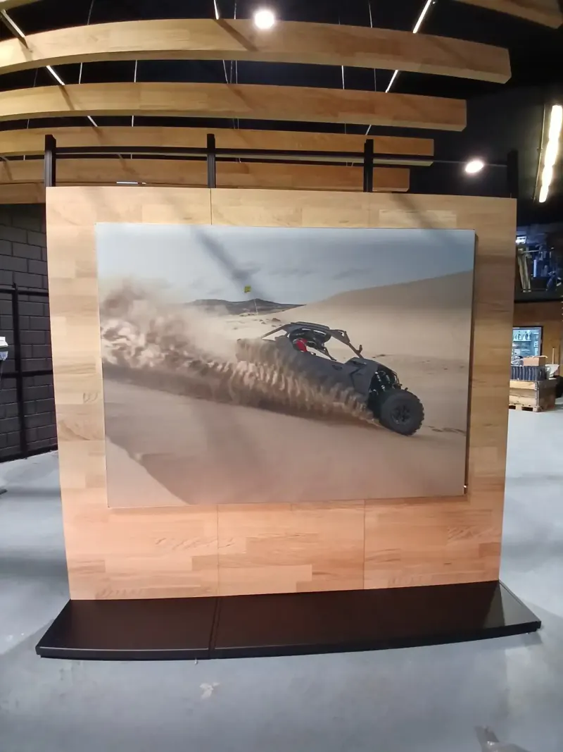 Rigid printed board mounted flat on an interior wall showing a full-colour dune buggy photograph